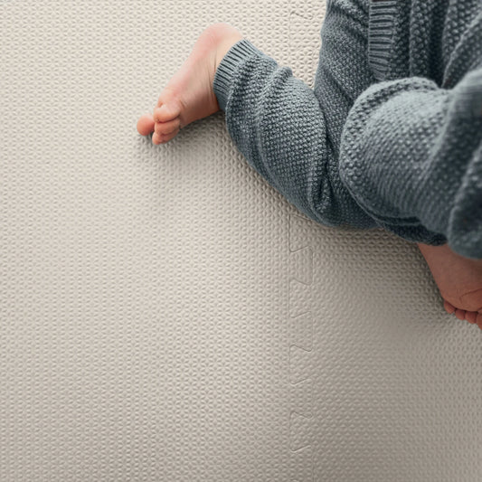 Baby enjoying time on a textured, non-toxic EVA puzzle playmat in siesta sand